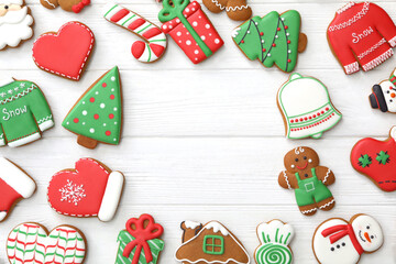 Fototapeta na wymiar Frame of different delicious Christmas cookies on white wooden table, flat lay. Space for text