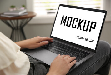 Woman working via modern laptop with text Mockup Ready To Use on screen, closeup