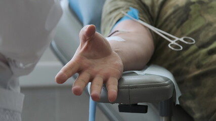 Blood donor at donation at medical centre. Close up footage arm of man receiving blood in hospital. Healthcare and charity. World blood donor day