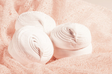 Fototapeta na wymiar White russian marshmallow , zephyr, close up with cornflower on pastel peach, light coral napkin. 