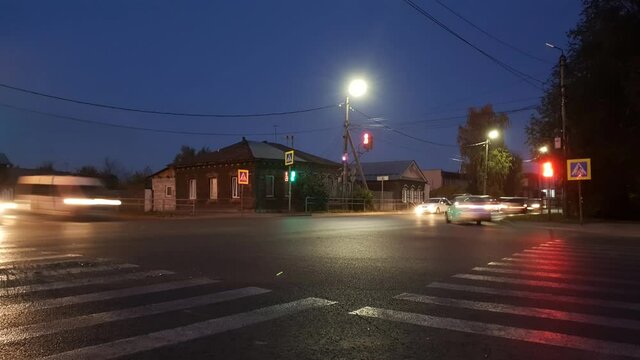 timelapse of a night city, cars driving through an intersection at a traffic light