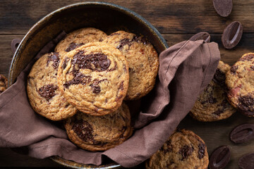 chocolate chocolate chip cookies on linen napkin on wooden table.