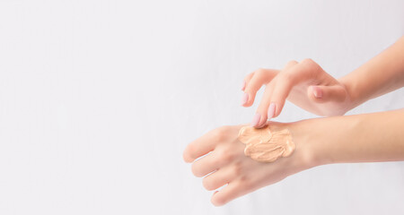 Make-up cosmetics concept. Hands with foundation texture. White background. Copy space. Banner