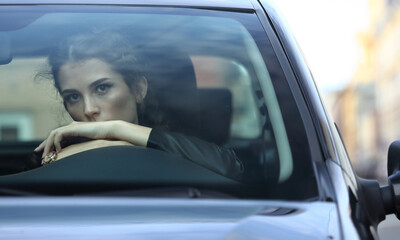 Beautiful girl behind the windshield of a car