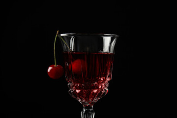 Delicious cherry wine with ripe juicy berries on black background, closeup