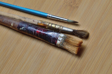 old art brushes on a wooden surface. close-up.