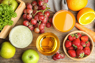 Glasses of delicious juices and fresh fruits on wooden table, flat lay