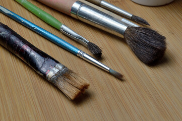 old art brushes on a wooden surface. close-up.