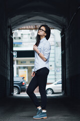 Beautiful Asian girl dressed in casual style standing in a street arch.