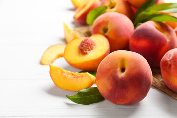Fototapeta na wymiar Fresh sweet peaches on white wooden table, closeup