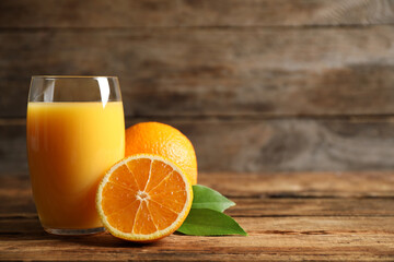 Glass of orange juice and fresh fruits on wooden table. Space for text