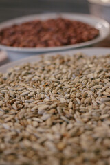 Obraz premium Roasted sunflower seeds in a plate in the foreground and peanuts in the background. Close-up.Macro shot. Selective focus.