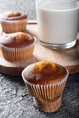 Muffins with milk on a wooden Board. Sweet muffins with berry filling on the table.