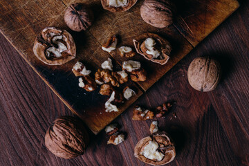 Walnut kernels and whole walnuts on rustic old wooden table. Top view.