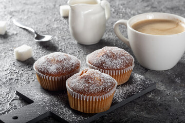 Coffee muffins on a wooden Board. Sweet muffins with berry filling on the table.Muffins sprinkled with powdered sugar.