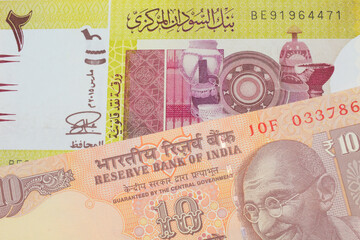 A macro image of a orange ten rupee bill from India paired up with a green two pound bank note from Sudan.  Shot close up in macro.