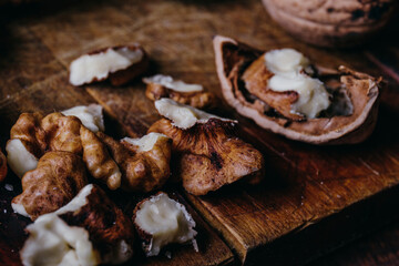 Cracked walnut kernels. Close-up on rustic old wooden table. Macro shot.