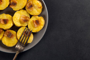 Baked potatoes with lard, a strata-fast delicious lunch, in a plate on a stone table. Copy space.