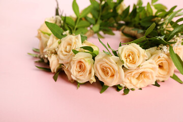 Wreath made of beautiful flowers on pink background, closeup