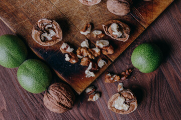 Walnut kernels, whole walnuts and green walnuts on rustic old wooden table. Top view.