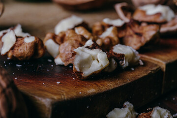 Cracked walnut kernels. Close-up on rustic old wooden table. Macro shot.