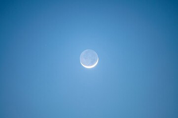Naklejka na ściany i meble Crescent moon glowing in blue sky