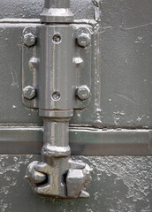 Lock used to open and close one of the doors of a container painted in gray. This lock is from a container house located in Balneário Gaivota, Santa Catarina, Brazil.