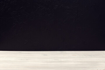 Empty white wooden table table on black textured wall background