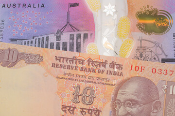 A macro image of a orange ten rupee bill from India paired up with a colorful five dollar bill from Australia.  Shot close up in macro.