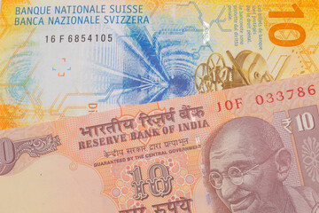 A macro image of a orange ten rupee bill from India paired up with a yellow Swiss ten franc bill.  Shot close up in macro.