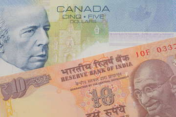 A macro image of a orange ten rupee bill from India paired up with a blue five dollar bill from Canada.  Shot close up in macro.