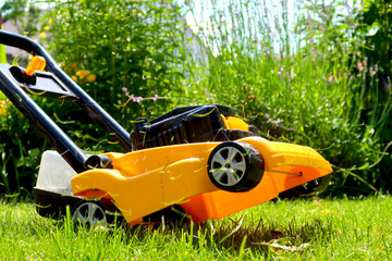 Yellow kids' lawn mower toy pretending to cut the grass