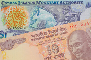 Fototapeta premium A macro image of a orange ten rupee bill from India paired up with a colorful one dollar note from the Cayman Islands. Shot close up in macro.