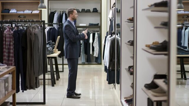 A side view panoramic demonstration of a business man finding a new look for himself and taking a picture of himself to share it on social networks