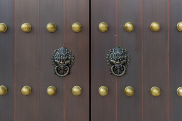 The door and knockers of Chinese temple. Ancient Asian door from temple. Chinese door. Oriental design of door of palace hall in Forbidden City. 
