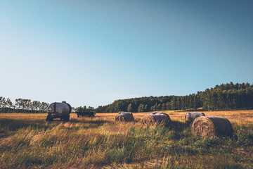 EIn leerstehendes landwirtschaftliches Fahrzeuge im Sommer auf Feld und Wiesen direkt am Wald im Sommer bei strahlend blauen Himmel. Bäuerlich Ackerbau Landwirtschaft im Pflugfeld des Traktors © Jakob