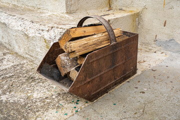 Old coal bucket filled with wood chops 
