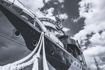 Nahaufnahme eines Haltetaus von einem großen Schiff am Hafen in Polen. Nach oben schauen an einem großen Tau entlang Richtung Kriegsschiff in schwarzweiss monochrom.