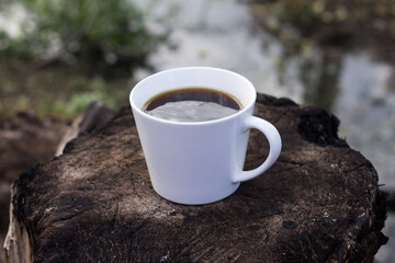white coffee cup on wood stand with blurred background