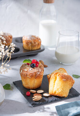 freshly baked muffins with berries on a white table with a glass of milk