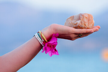 A woman hand holding a colorful stone of Crete mountains