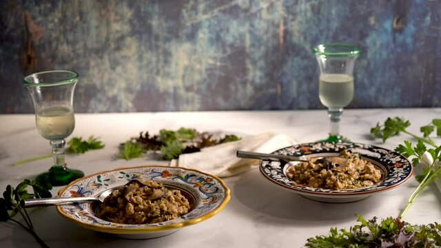 Slider to left turning of Italian bowls of shiitake kale risotto with wine.