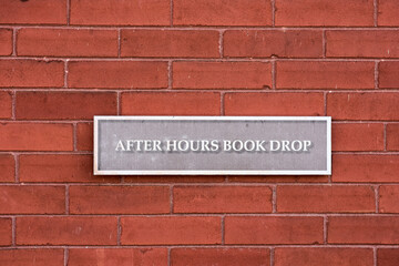 After hours book drop sign at a public library.