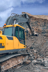 Obraz premium the process of loading soil with an excavator bucket into a truck at a construction site