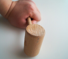 wooden hammer held by an arm