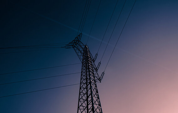 Stromast fotografiert im Sommer w&auml;hrend eines wolkenlosen Himmels im minimalistischen Stil in freier Natur. Konstruktion f&uuml;r die Aufh&auml;ngung einer elektrischen Freileitung. Tragmast & Freileitungsmast