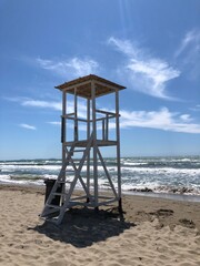 A white lifeguard tower on the beach .