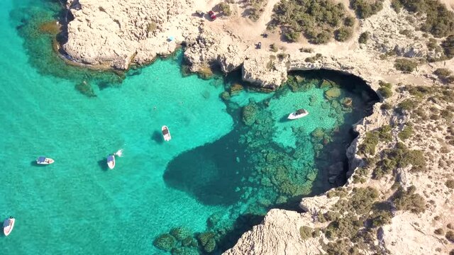 A beachfront bay in the ocean with blue water and beach - Blue Lagoon - Cyprus - Boats in blue sea