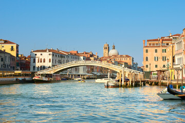 Fototapeta na wymiar Traditional houses and foot bridge across on Grand Canal in Venice, Italy.