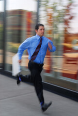 Blurred businessman running on the sidewalk